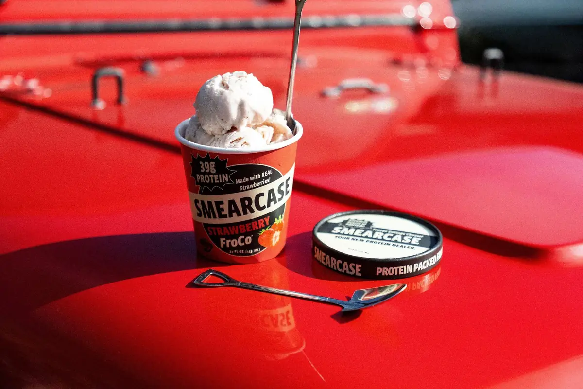 A pint of Smearcase FroCo on the hood of a red car